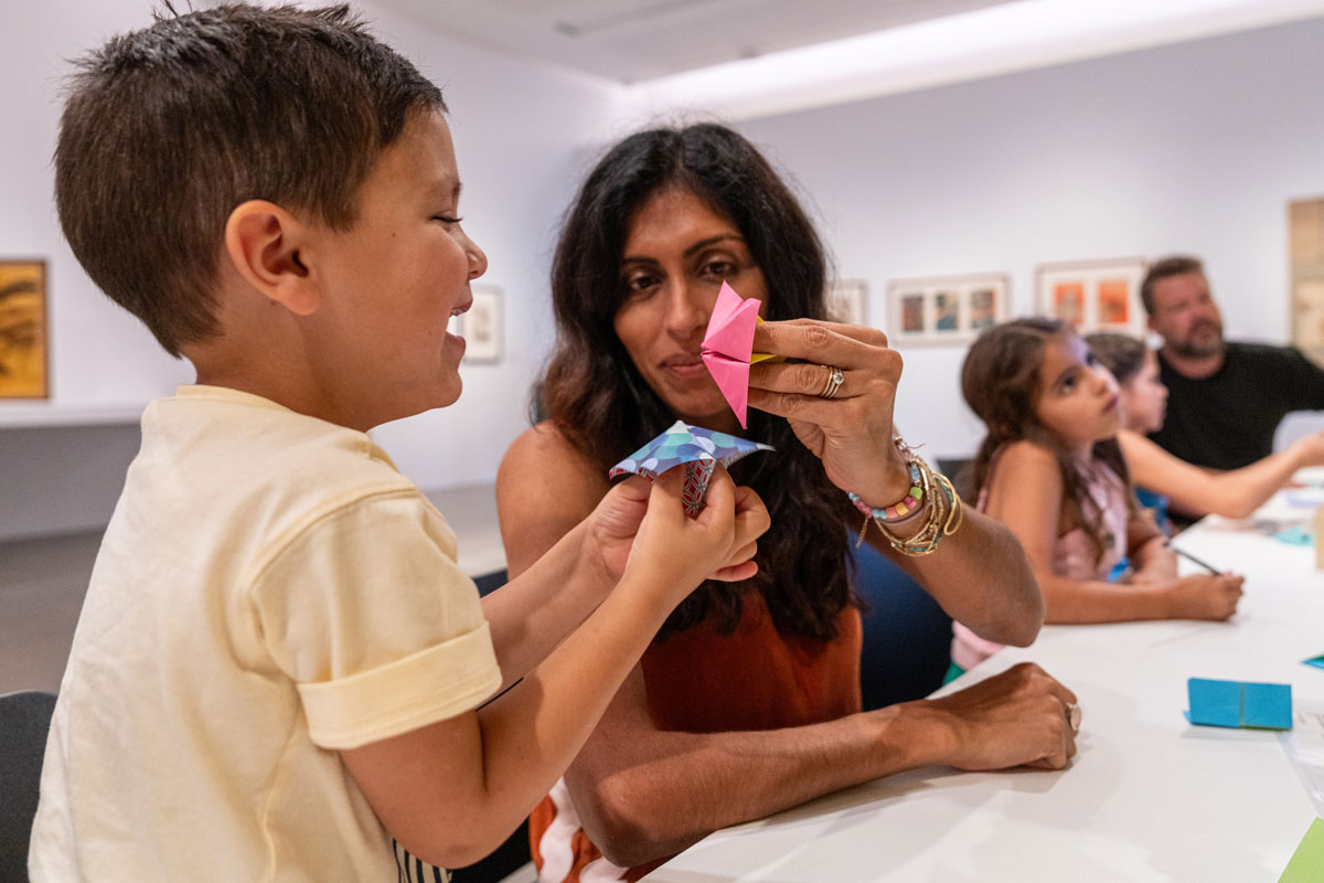 Parent and child folding origami at RMOA