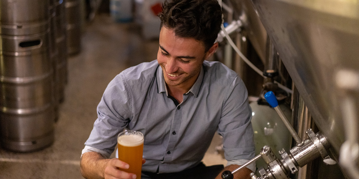 a man holding a craft beer during a beer tasting