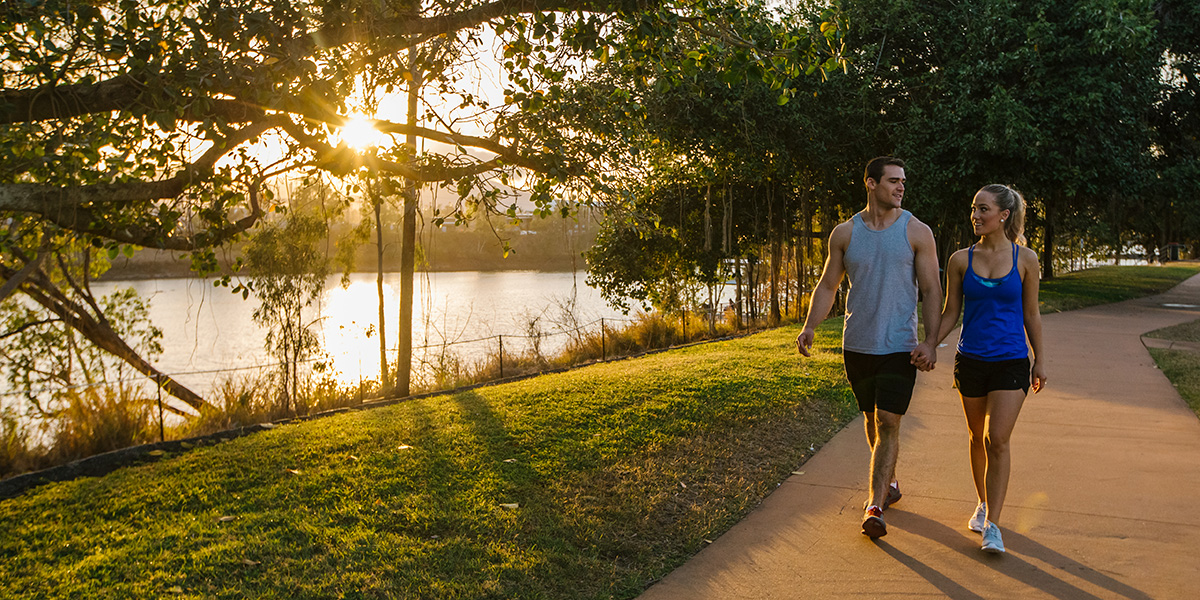 a couple walking along a riverside footpath