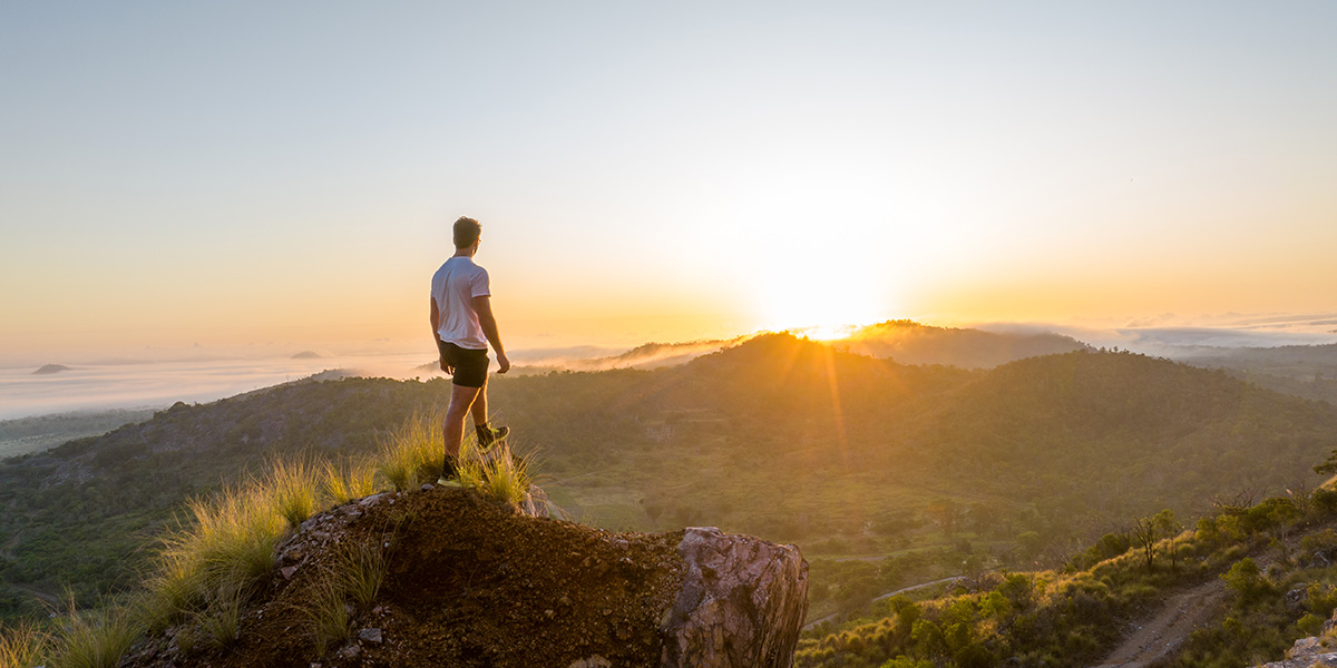 a man standing on a mountain top overlooking mountains