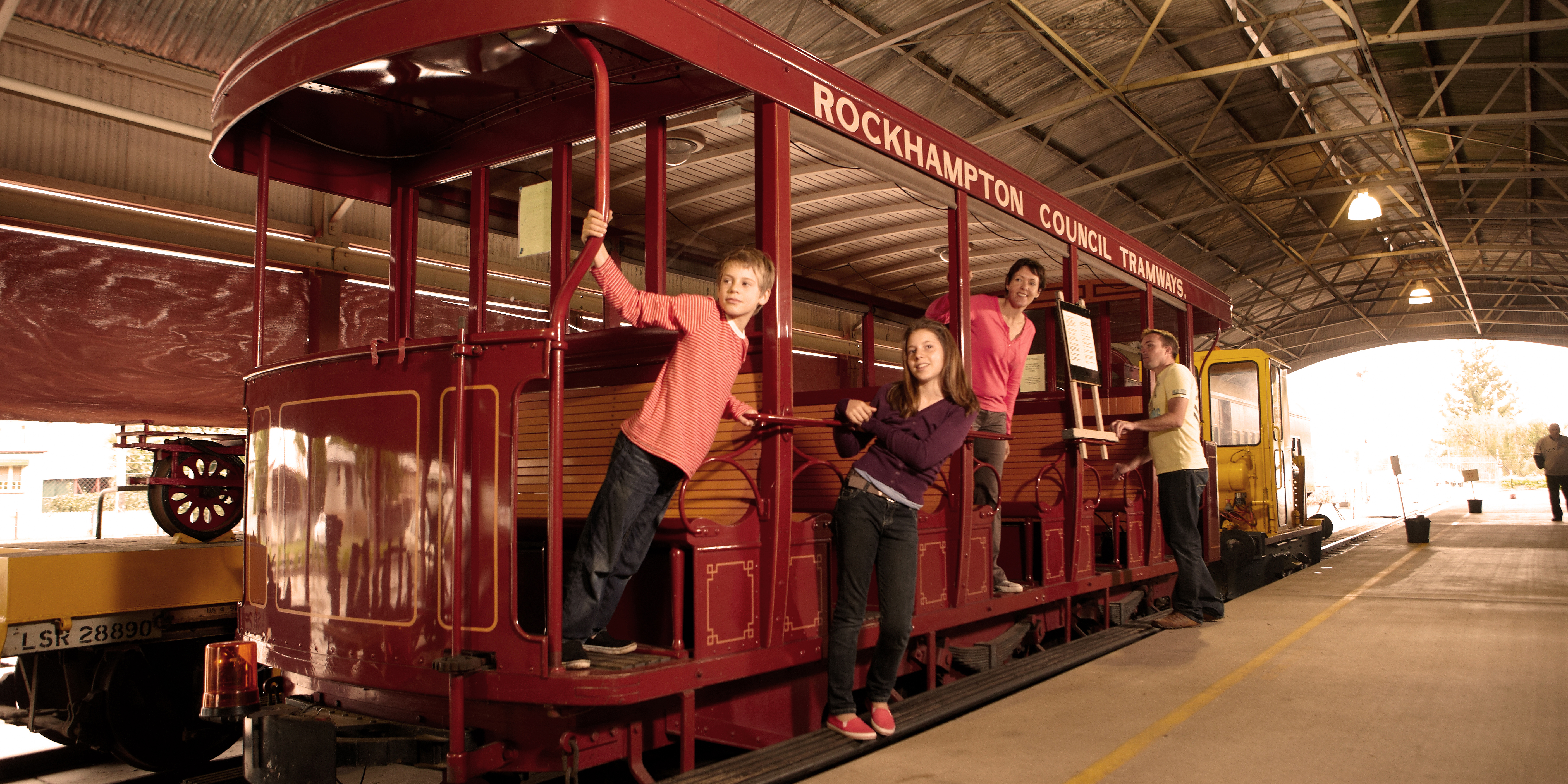 Kids standing on the purrey tram at Archer Park Railway Museum