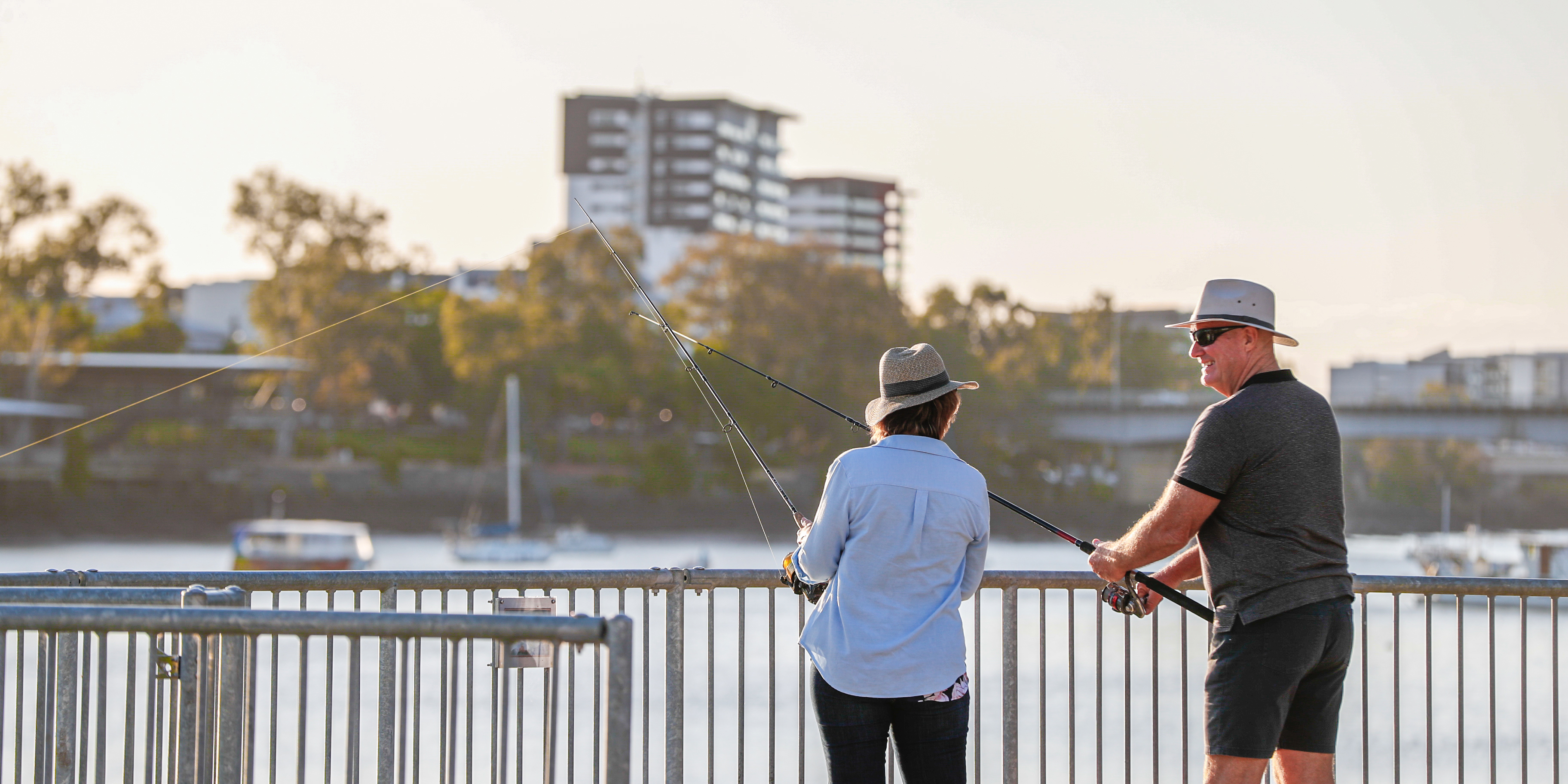 Woman and man fishing off a bridge into the Fitzroy River