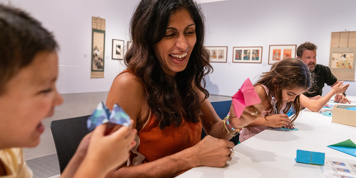 Family of six making origami at an art workshop at Rockhampton Museum of Art.