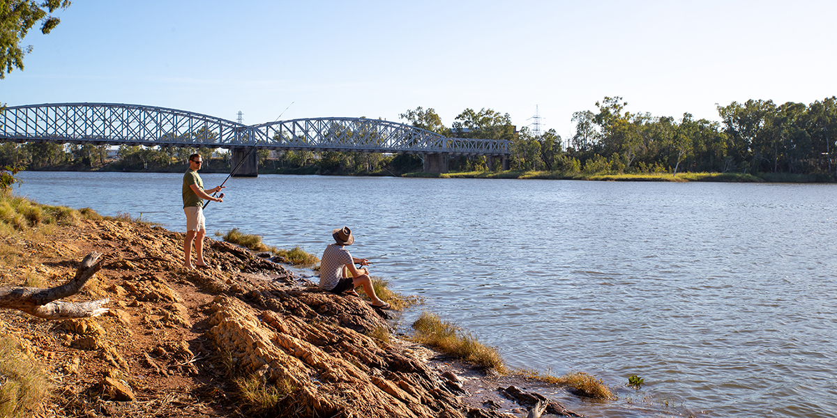 Two men fishing off the banks of the Fitzroy River near Col Brown Park.