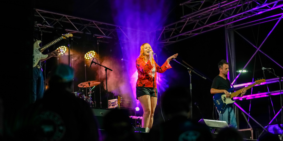 young woman singing on stage at night