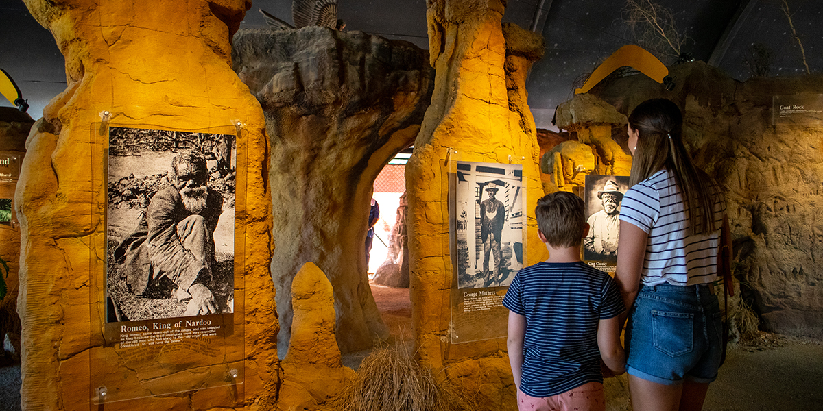 A young boy and girl look at Indigenous artefacts in a make-shift cave at the Dreamtime Cultural Centre.