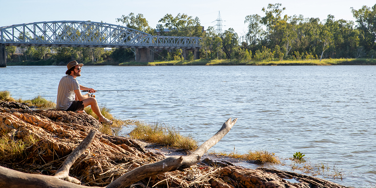 Young man fishing off the bank of the Fitzroy River.