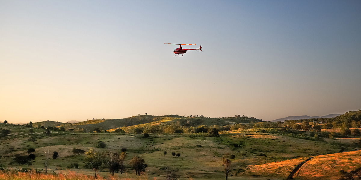 Mountainous plains with a helicopter in the distance