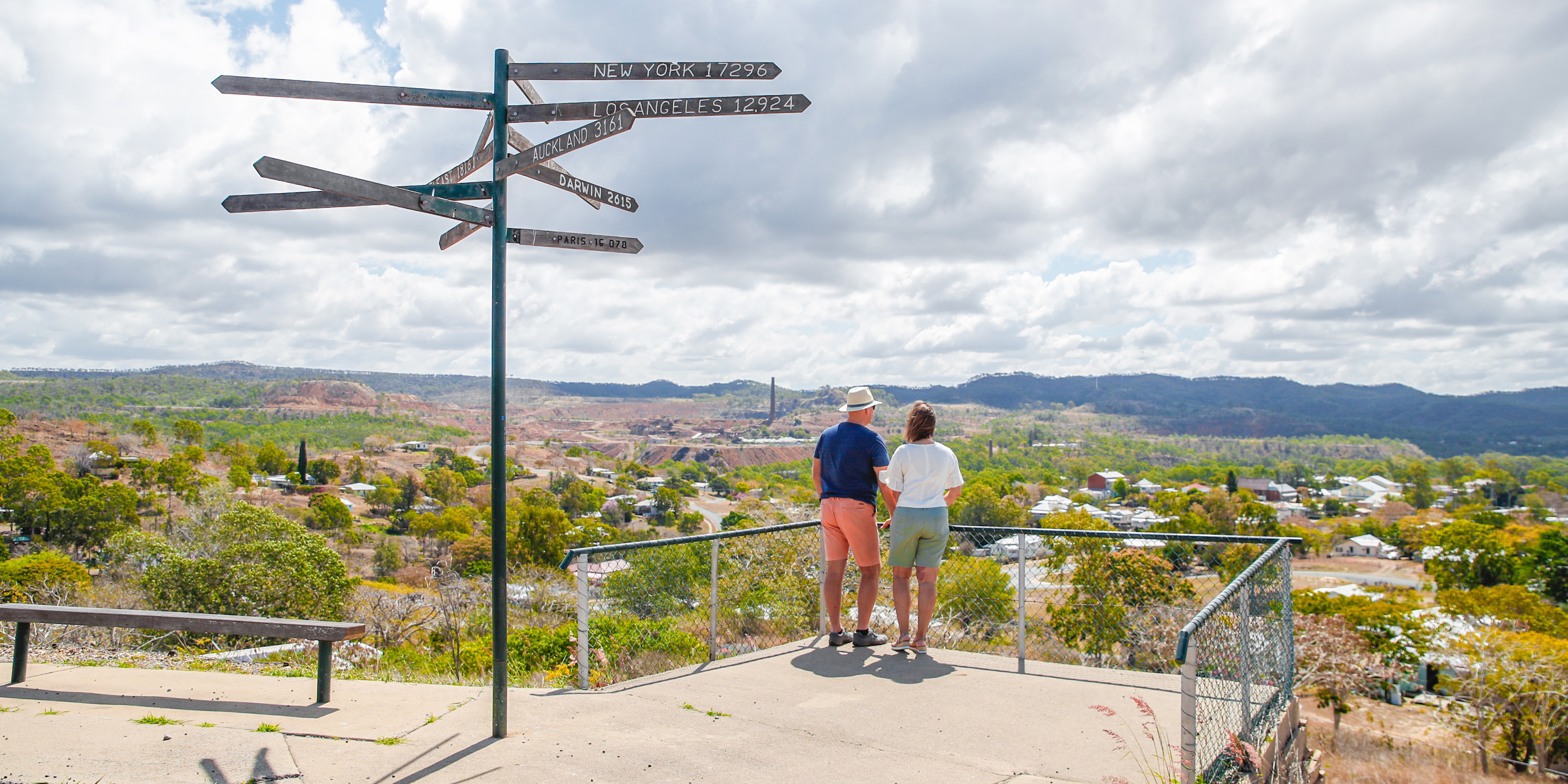 Middle aged couple standing together on a look out, overlooking the town of Mount Morgan