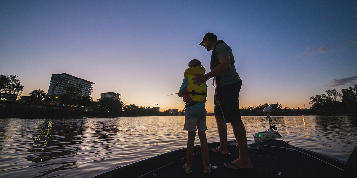 A father and son fishing on dusk in the Fitzroy River from a boat