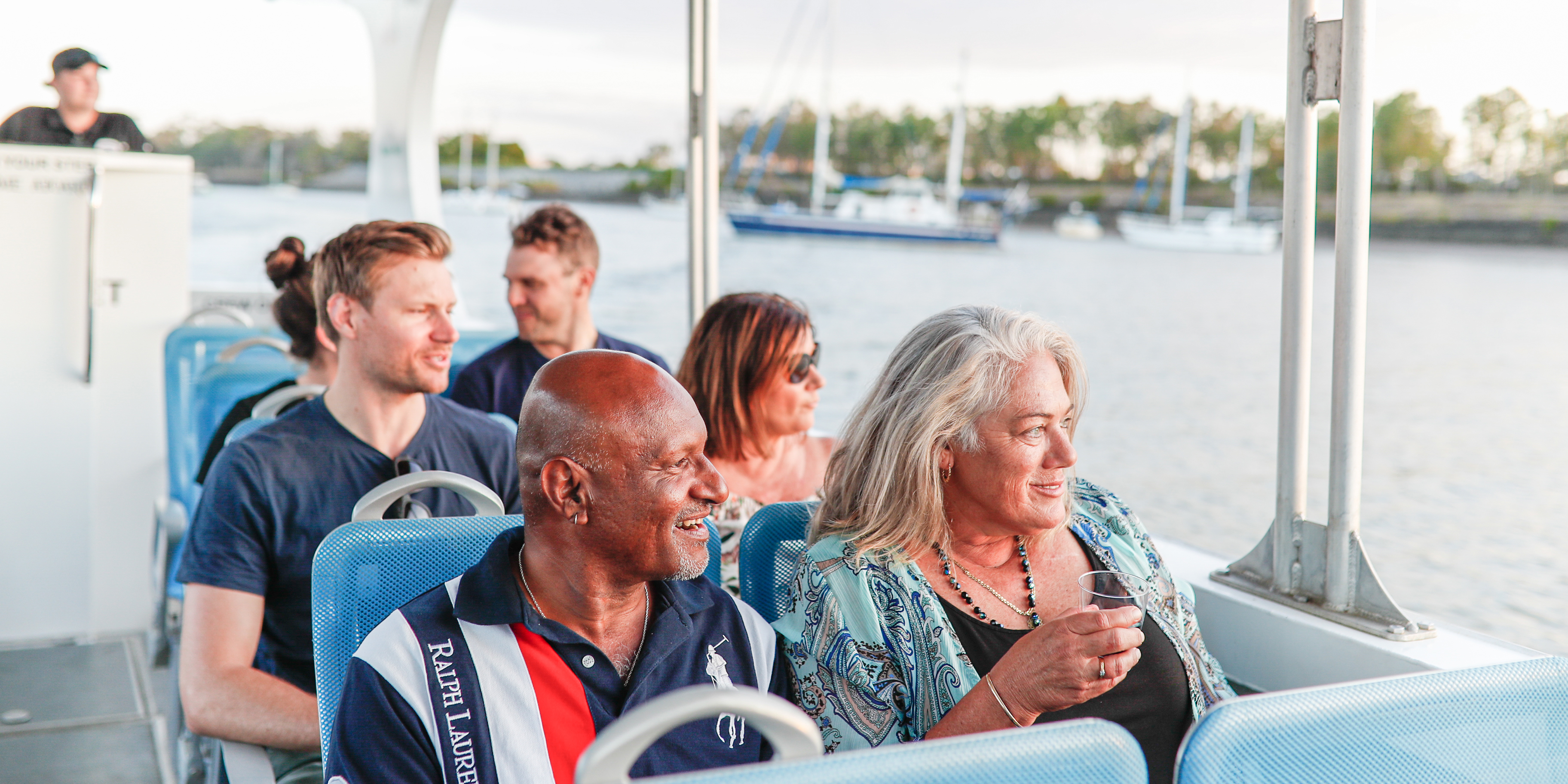 adults of all ages sitting in a boat enjoying a river cruise