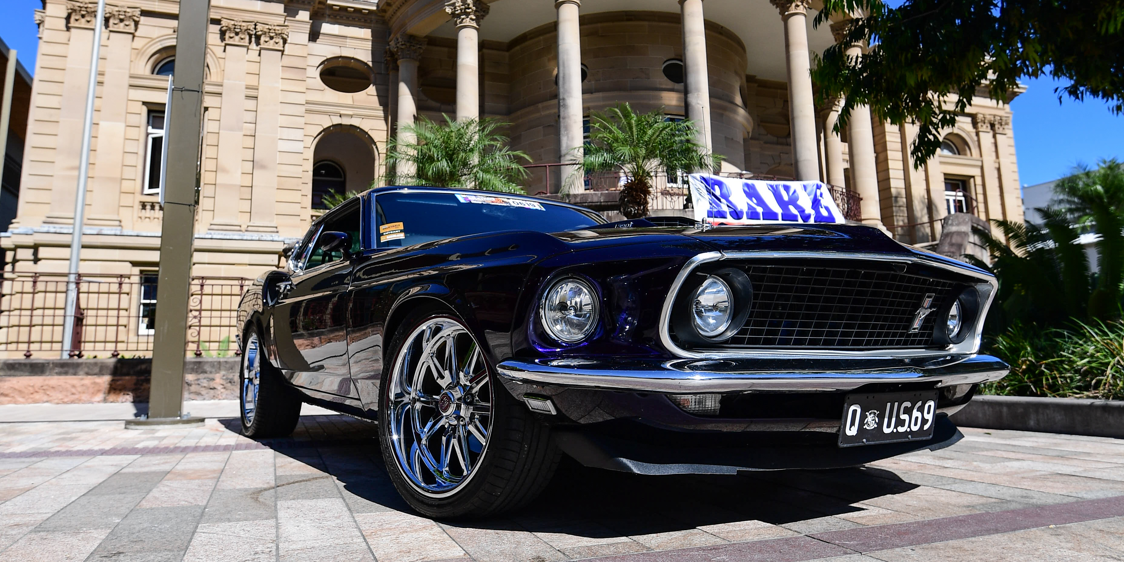 Show car photographed from a low angle with Customs House in the background