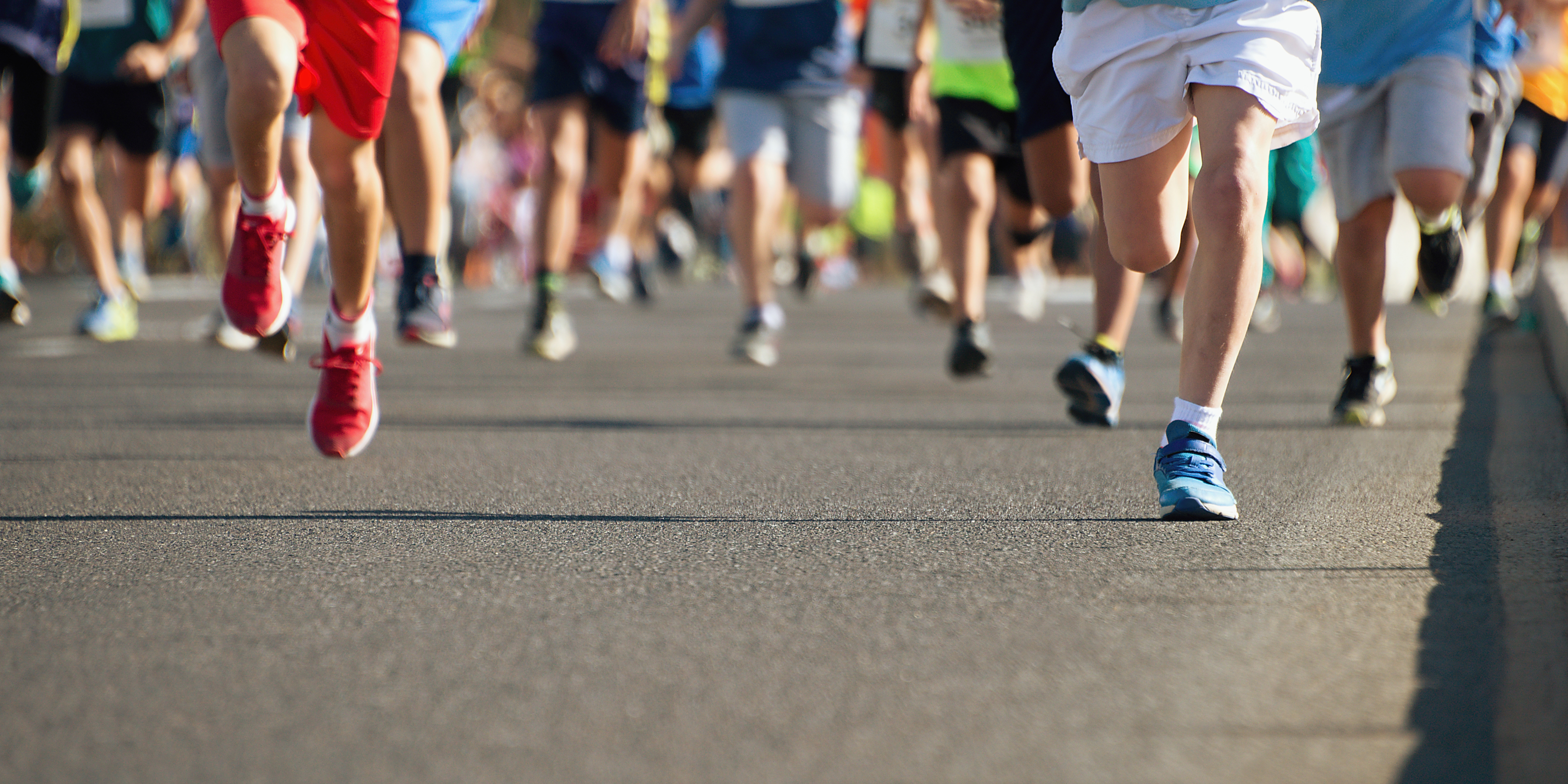 Hundreds of legs and feed running towards the camera in a triathlon