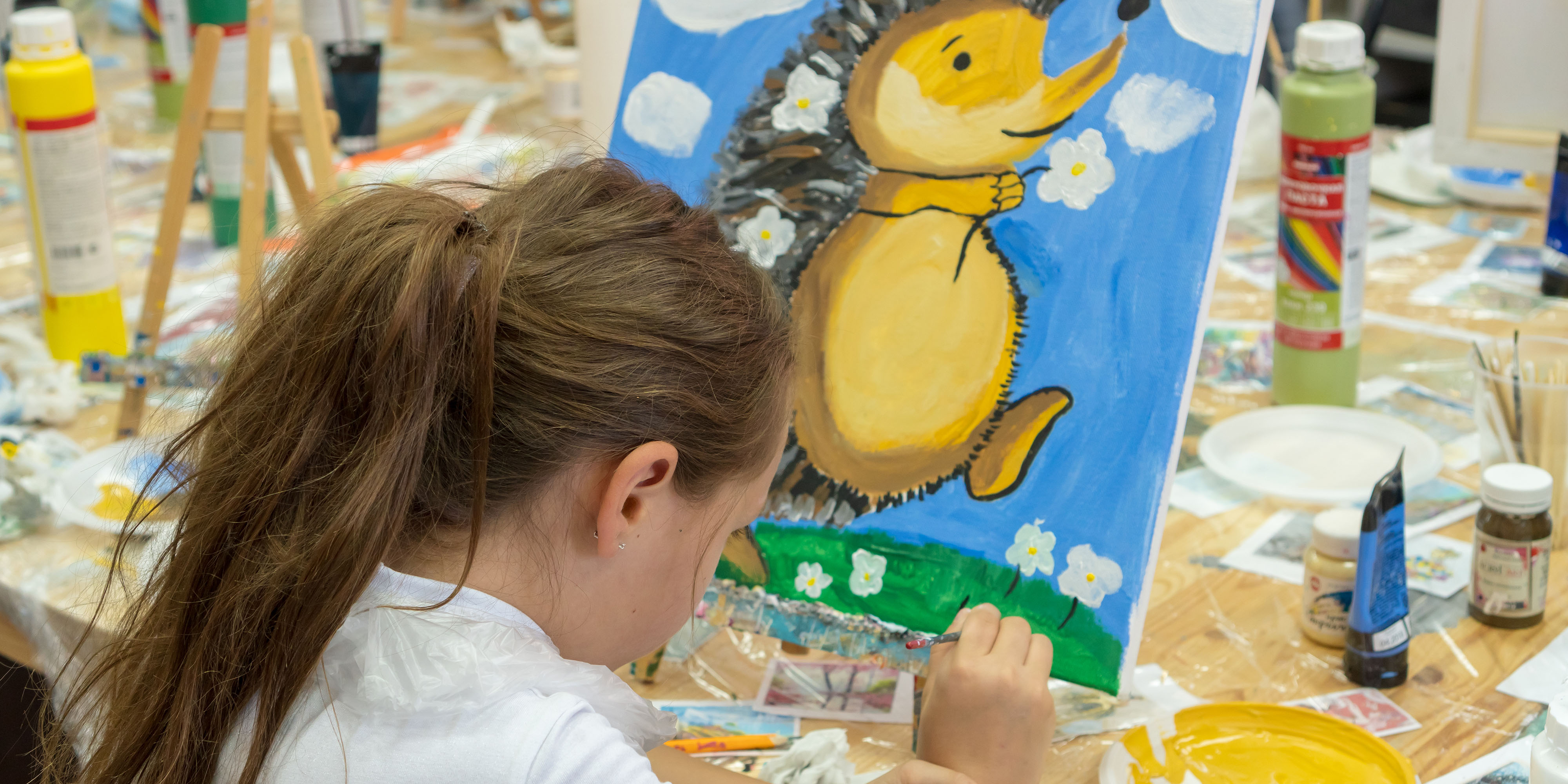 young girl painting on canvas