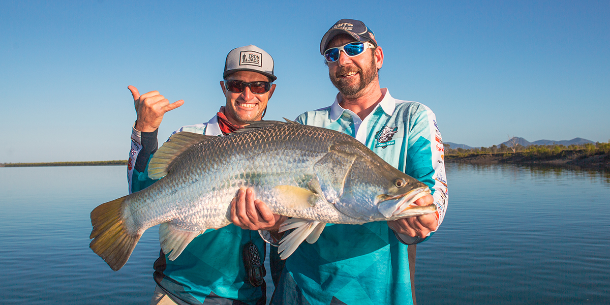 Who men holding a trophy sized barramundi