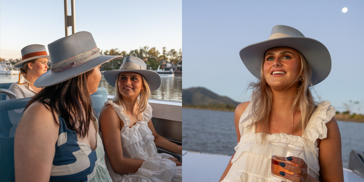 Young woman looking into the distance on a boat holding a beverage