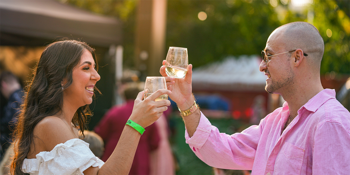 A young couple clinking glasses a the food and wine festival.