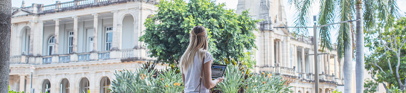 a woman holding a tablet doing a self-guided tour of heritage buildings