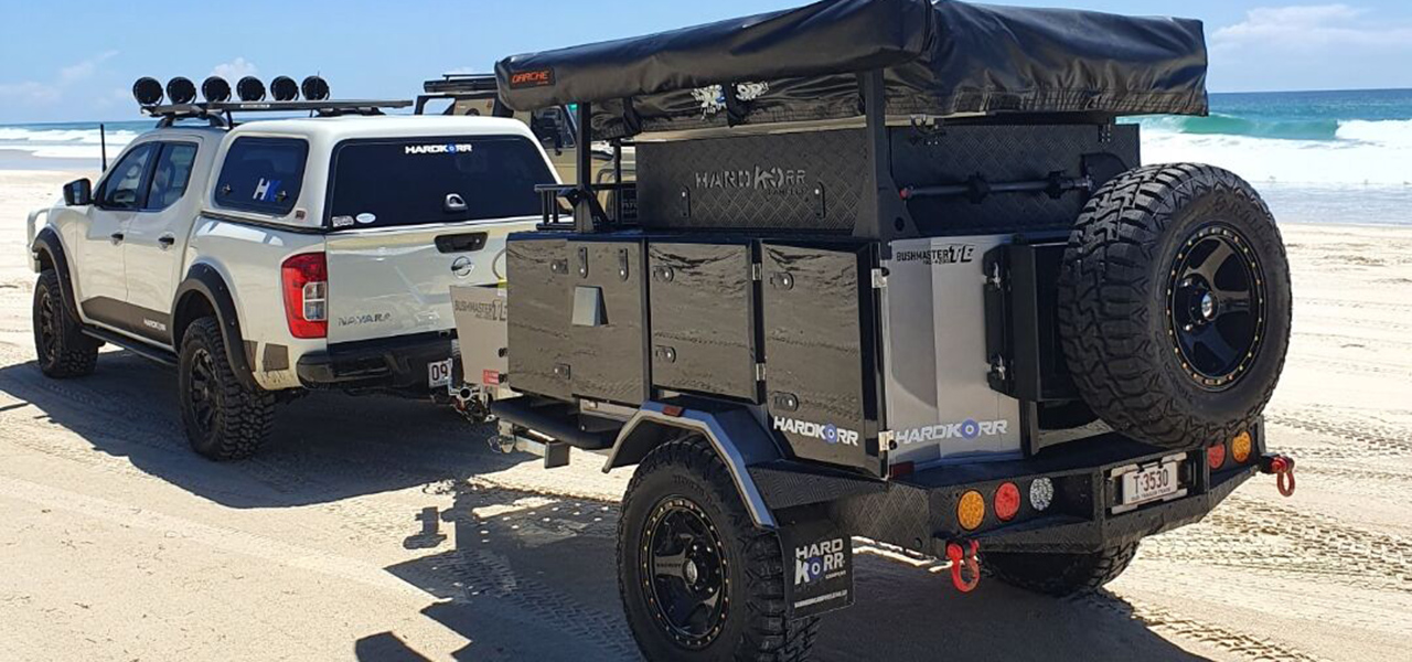 Caravan being towed on the beach by a Landcruiser 4x4.