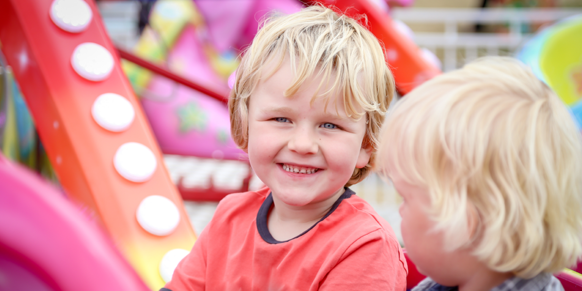 Happy caucasian boy smiling on ride at country show